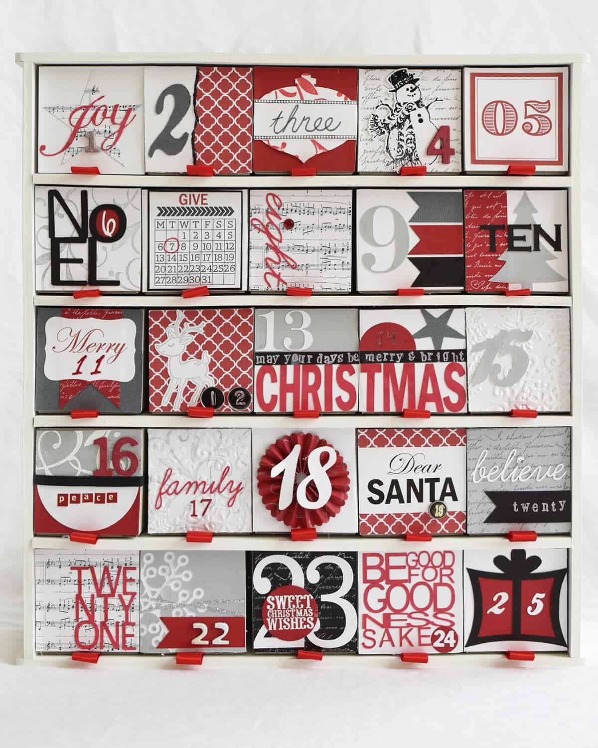 Black. white, and red Christmas advent calendar with little drawers made with scrapbook paper.