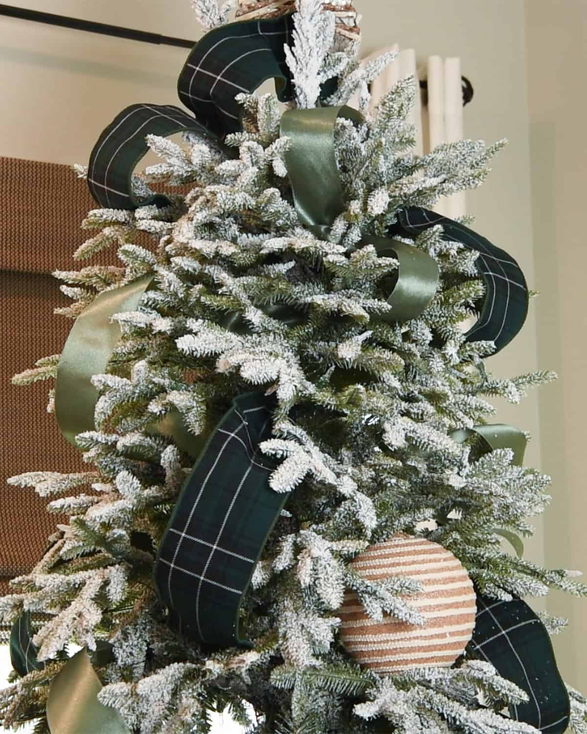 Christmas tree with green ribbon in multiple patterns.