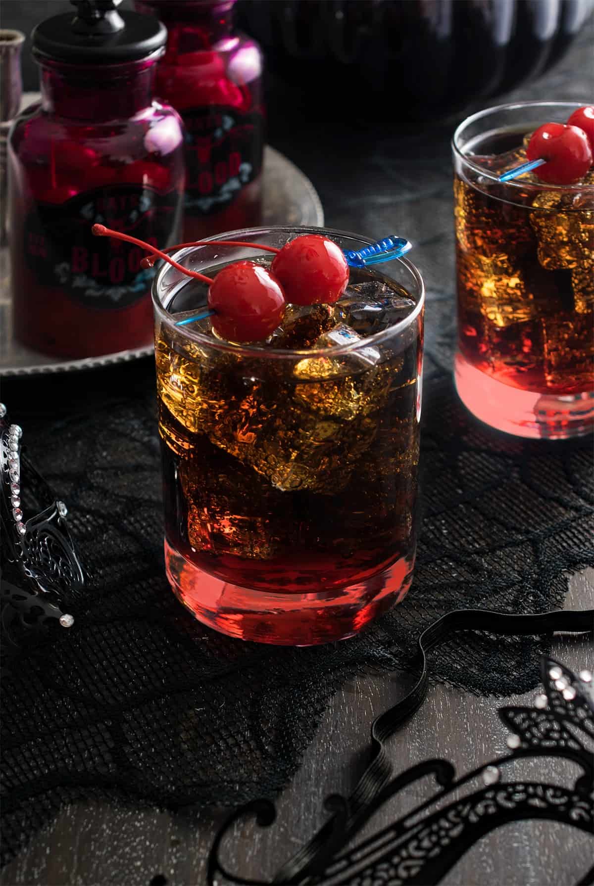 Rum and Coke Halloween Cocktail with red cherry garnish and grenadine.