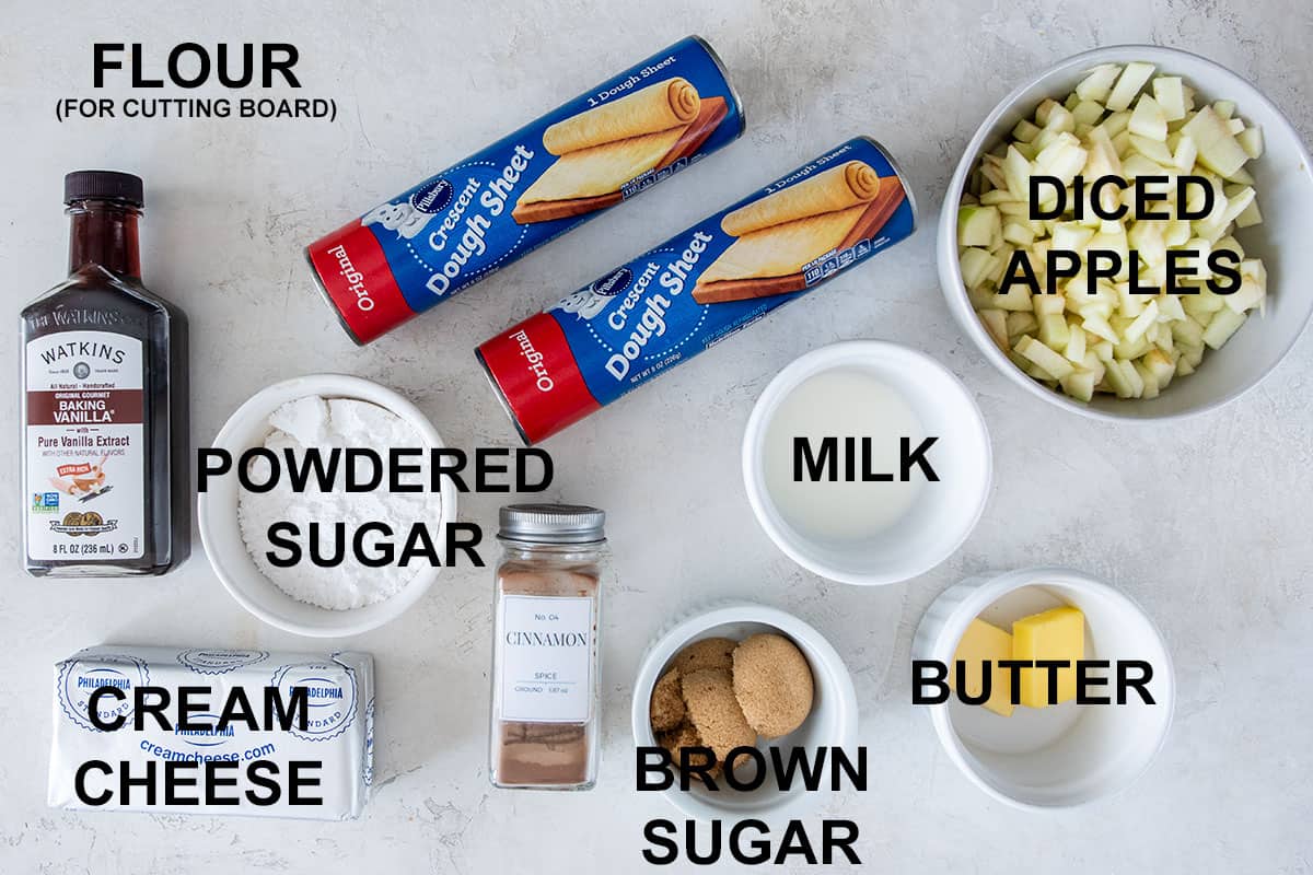 Overhead of ingredients to make apple cinnamon rolls on a board.