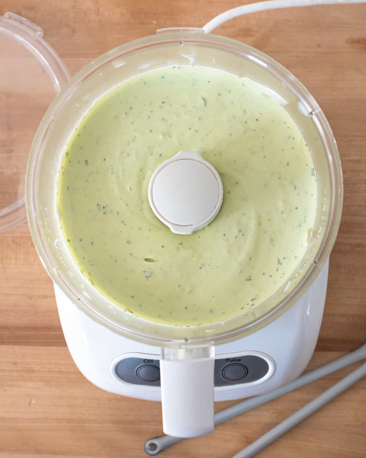 Smooth and creamy avocado sauce in blender.