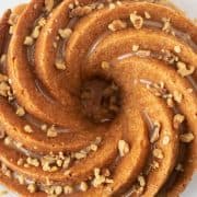 Aerial view of Bailey's Irish creme cake in a Beautiful bundt swirl pattern, topped with Bailey's caramel glaze and chopped walnut pieces.