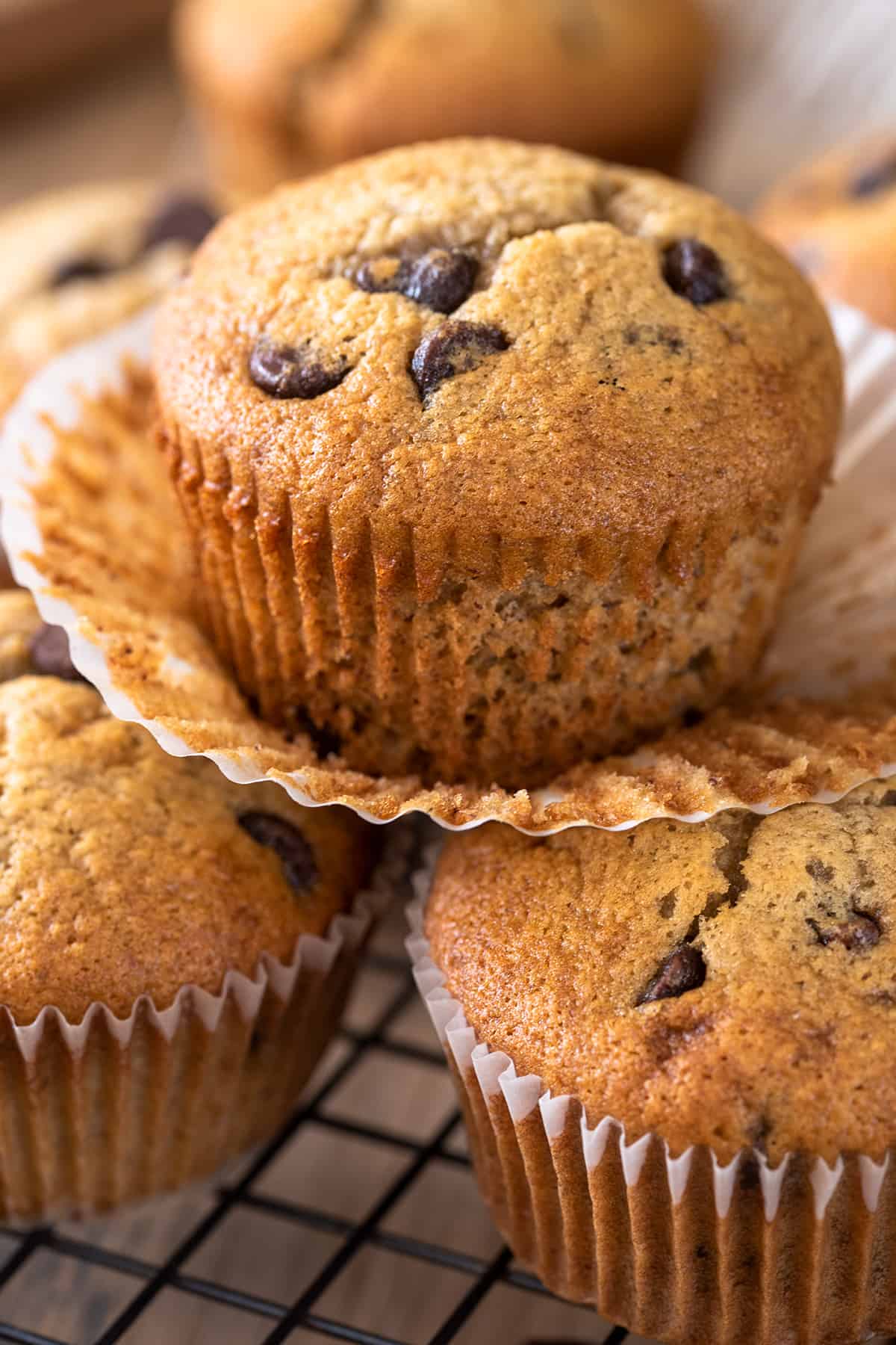 Banana Chocolate chip muffins stacked with top wrapper peeled off to show texture.