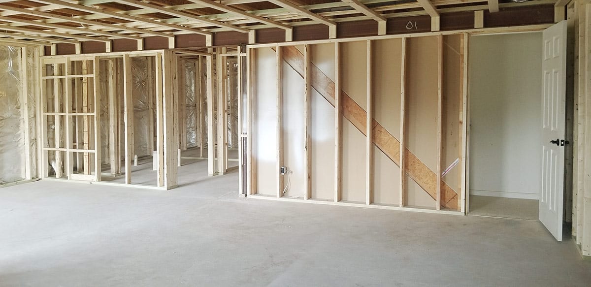 A framed basement in the process of construction with new walls and a bathroom.