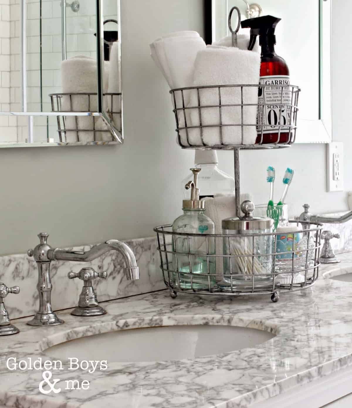 Chrome tiered basket tray with assorted bathroom toiletries including towels, soap, and toothbrushes.