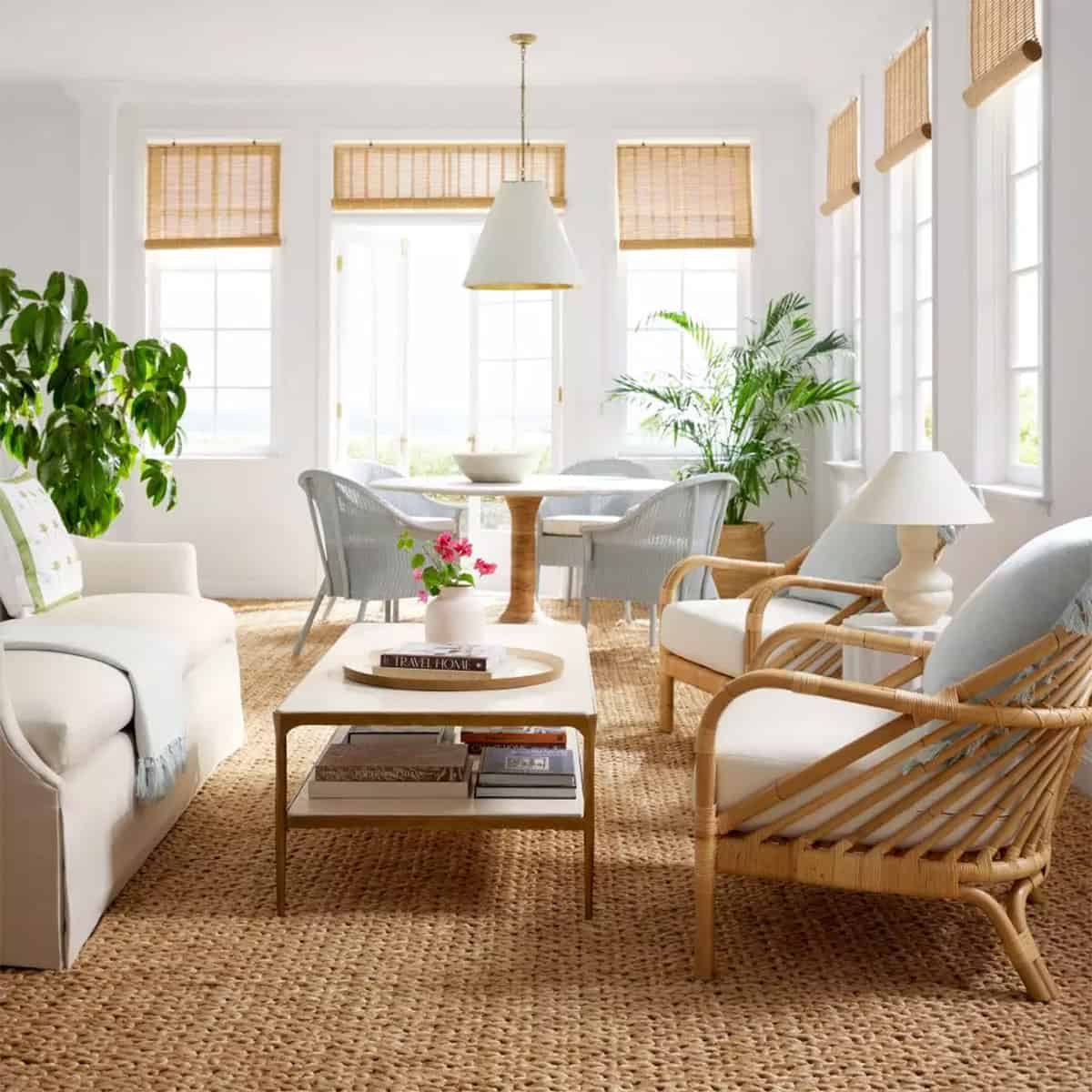 A cozy beach house vibe with outdoor rugs and fabric chairs in a white home.
