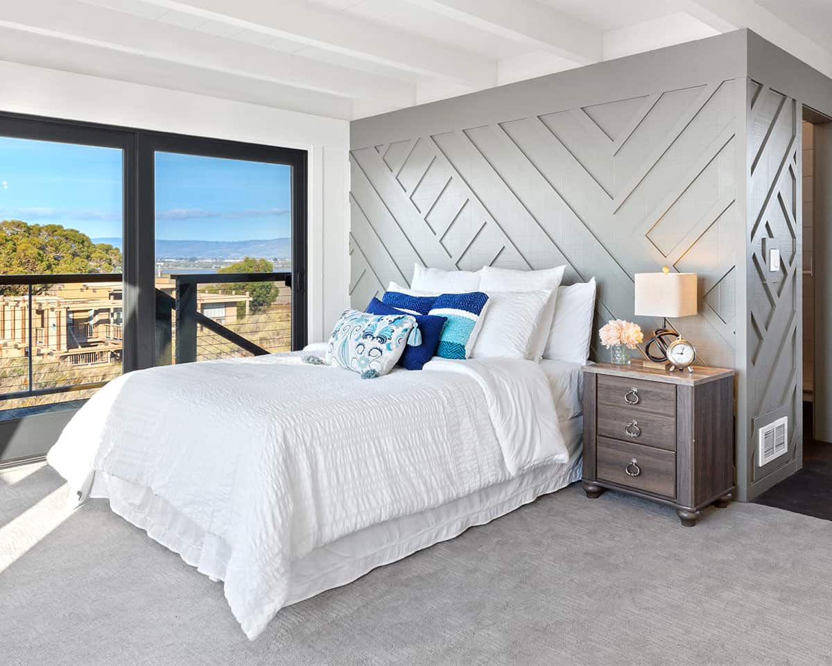 Wall molding placed in a geometrical pattern textured wall in a bedroom with windows.