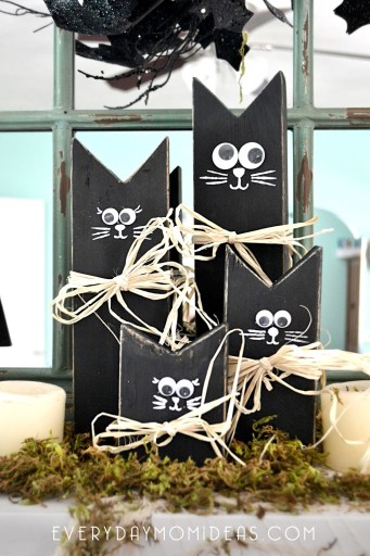 A group of painted black cats made from scrap wood.