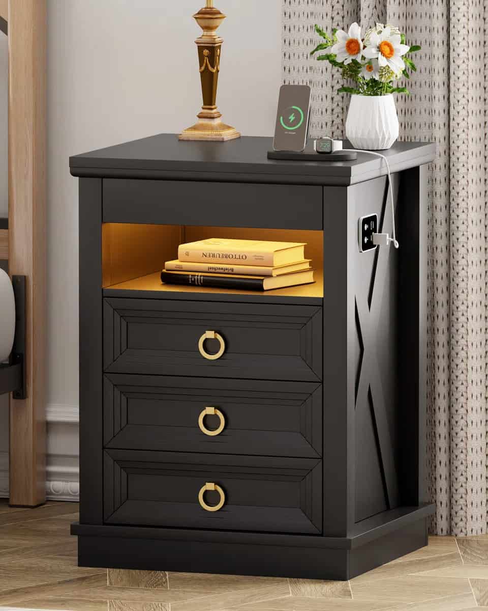 Black dresser with gold knobs and an X design on the side with charging station.