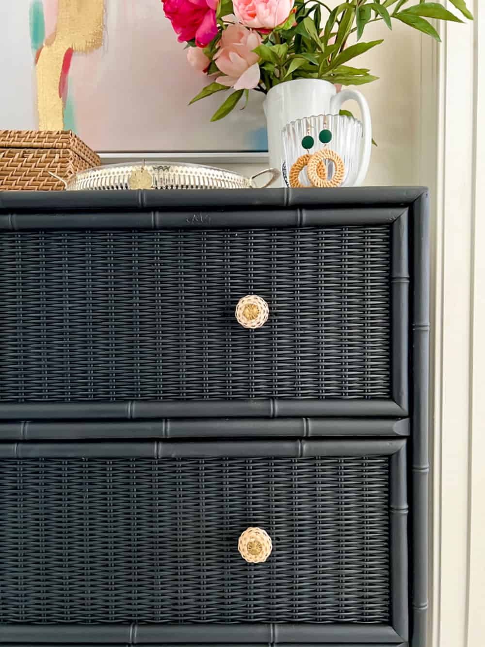 Black painted wicker dresser with gold knobs.