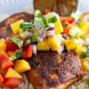 Blackened Mahimahi fish with mango salsa on a bed of rice.