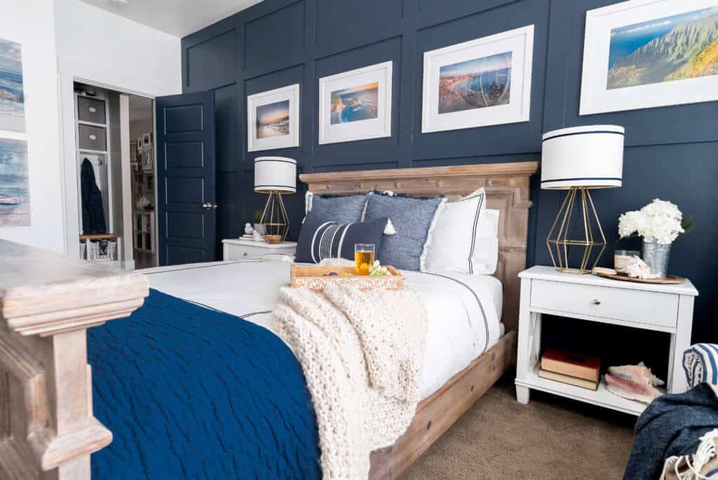 A Hale Navy board and batten accent wall with picture frames in a master bedroom.
