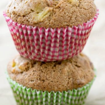 Two squash muffins stacked on top of one another in colorful wrappers.