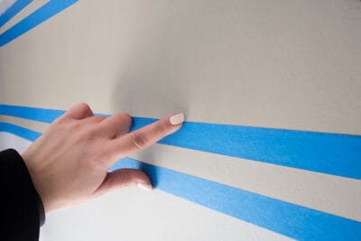 Woman using her finger to burnish edges of tape.