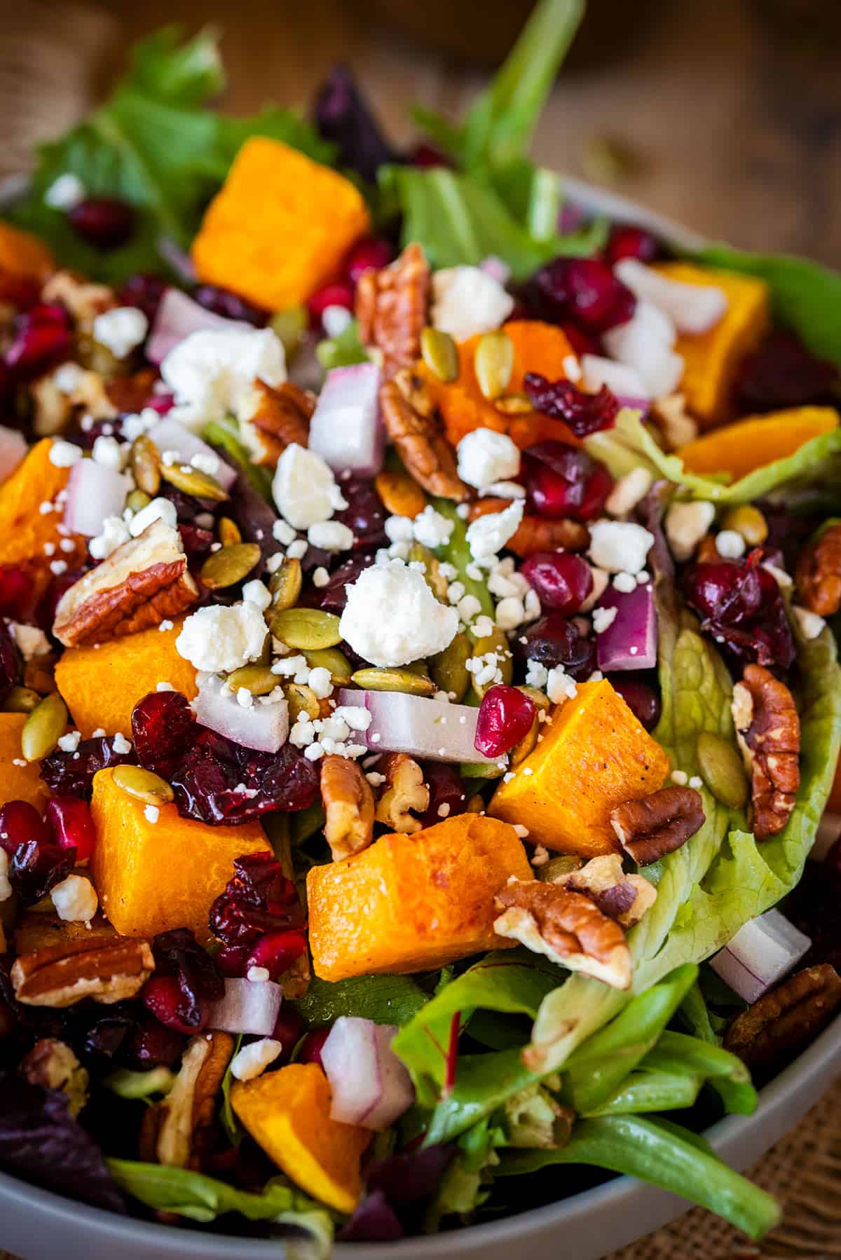 Closeup of butternut squash salad with toppings to show texture.