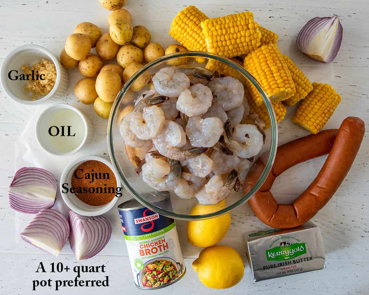 Ingredients for a Low Country shrimp boil but with Cajun seasoning and shrimp, corn, sausage, onions, potatoes, and lemons.