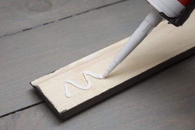 Adding caulk or wood glue to the back of a board