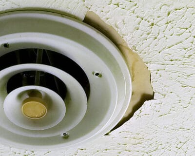 Ceiling vent closeup with water damage around it.