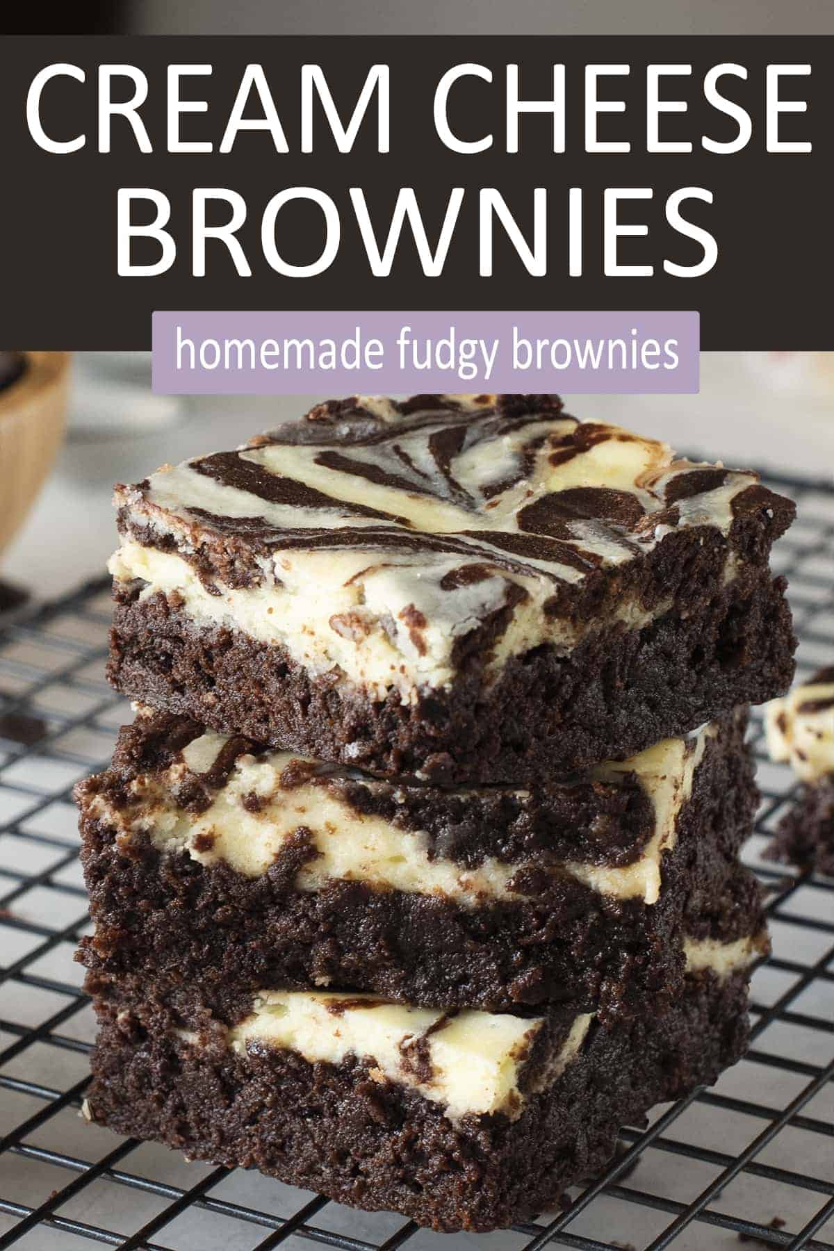 Stacked Cream Cheese Brownies on a wire background to show texture