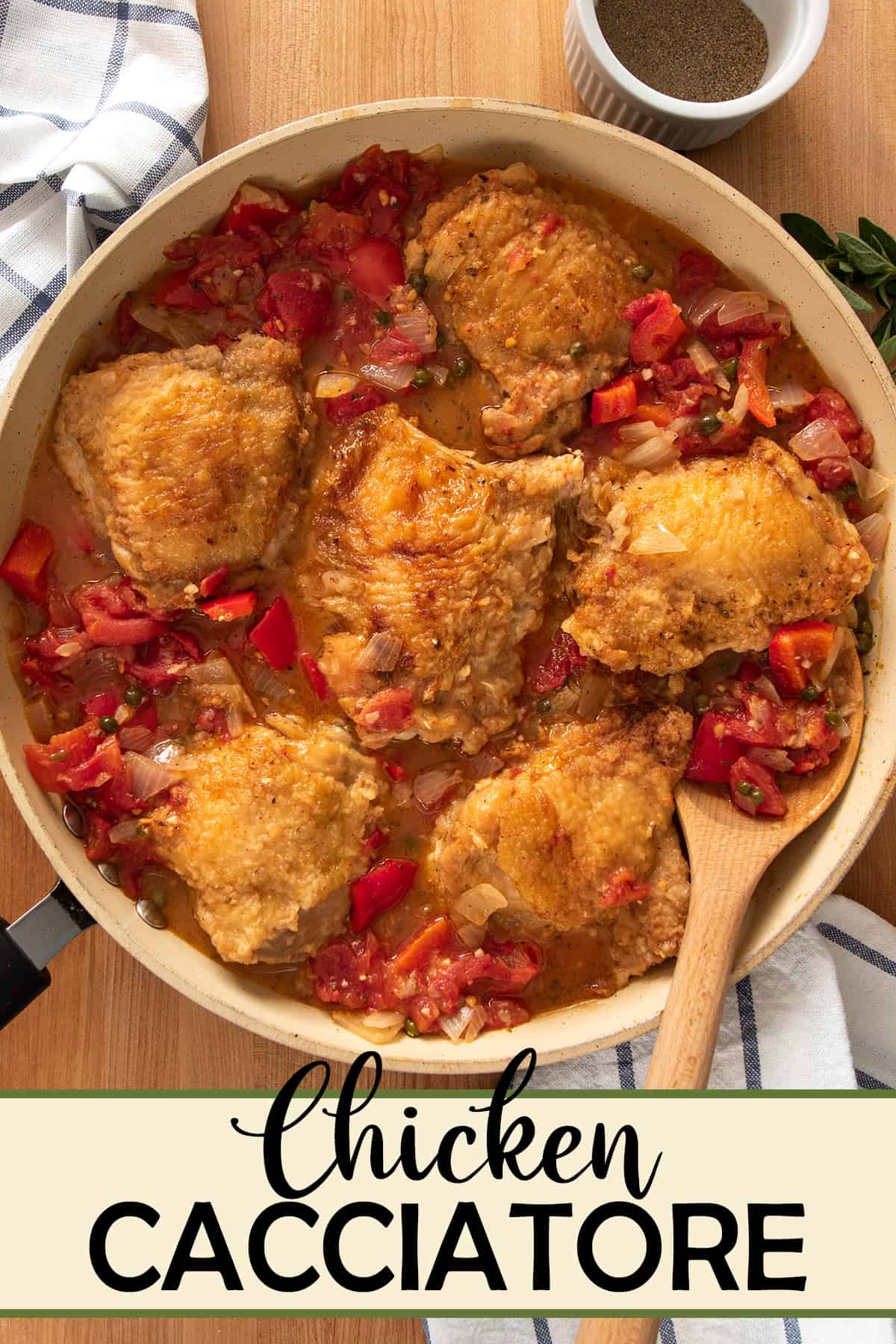 Overhead of Chicken Cacciatore with peppers and tomatoes stewed in a large skillet.