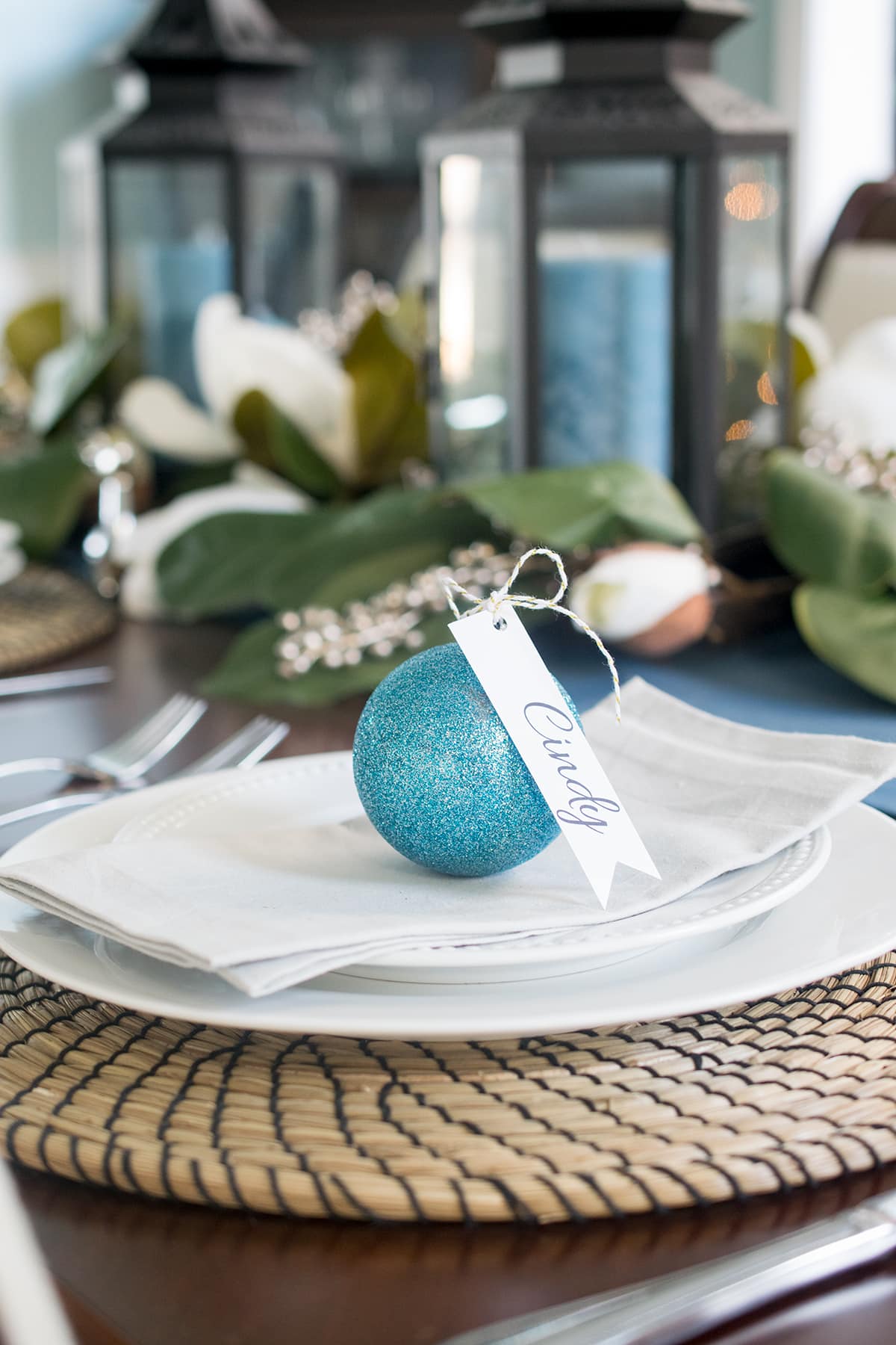 Dining table place cards for a Christmas party made out of ornament balls and name tags.