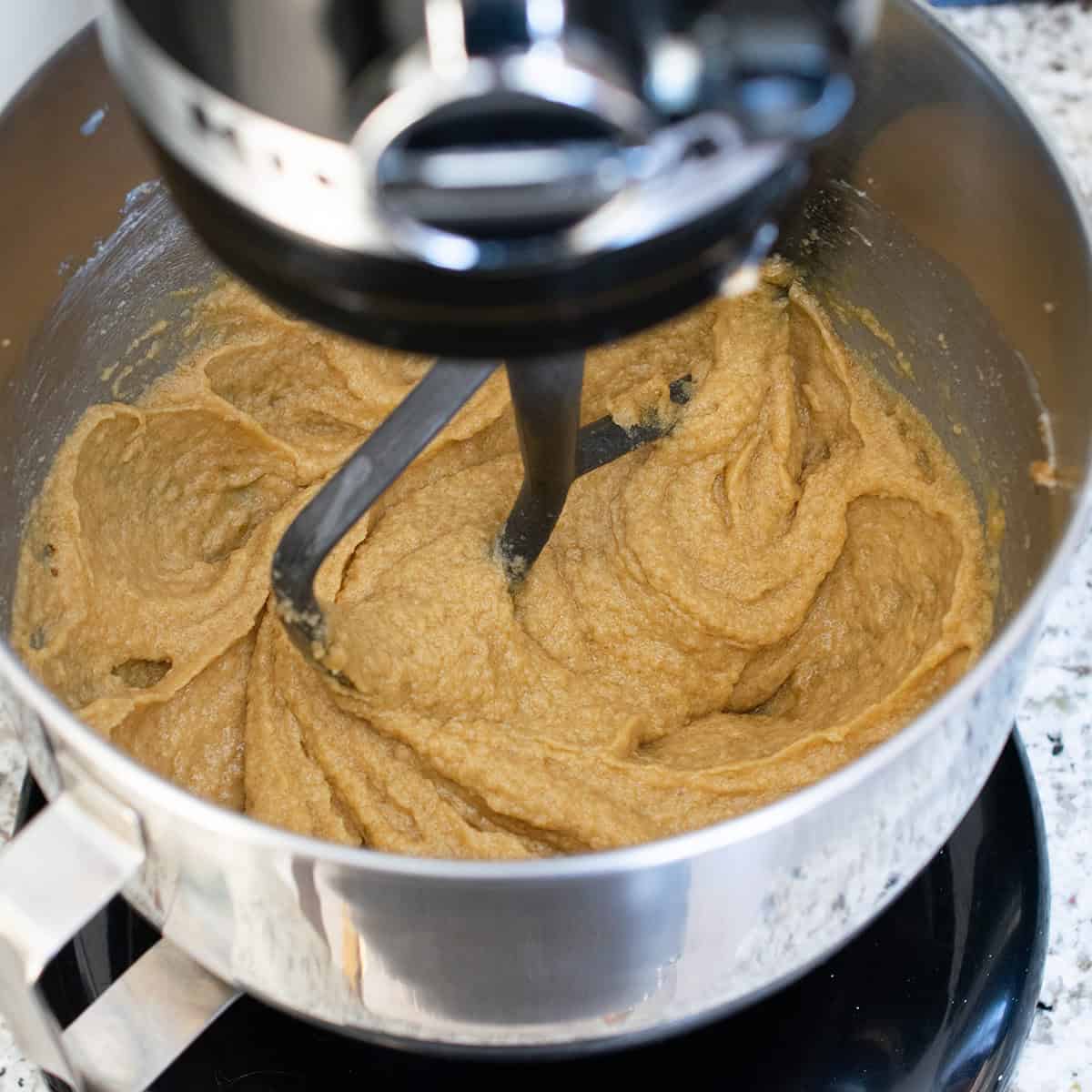 Pecan Oatmeal Cookie batter in a stand mixer showing texture of the coconut.