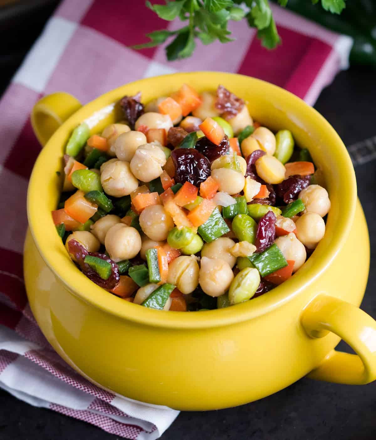 Chickpea Salad - A delicious chopped salad with lots of veggies, cranberries, and a tangy vinaigrette dressing in yellow crock