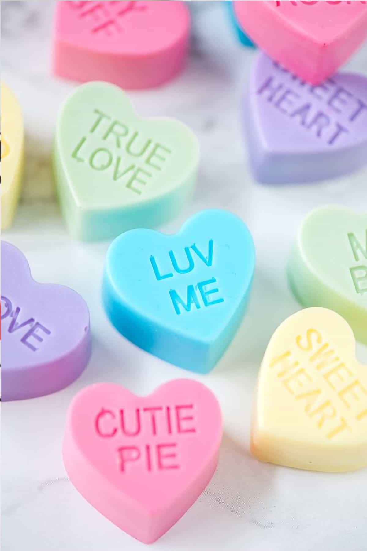 Single use conversation soap hearts in various colors laying on a white background.