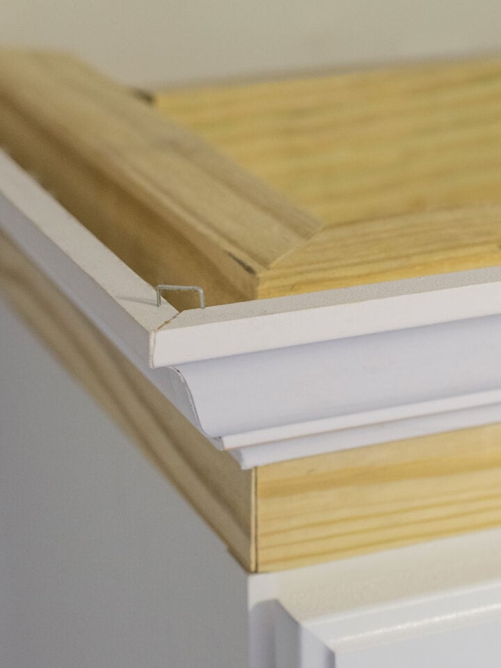 Closeup of crown molding corner on edges of cabinets.