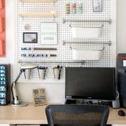 Desk area with large pegboard for craft and office supplies.