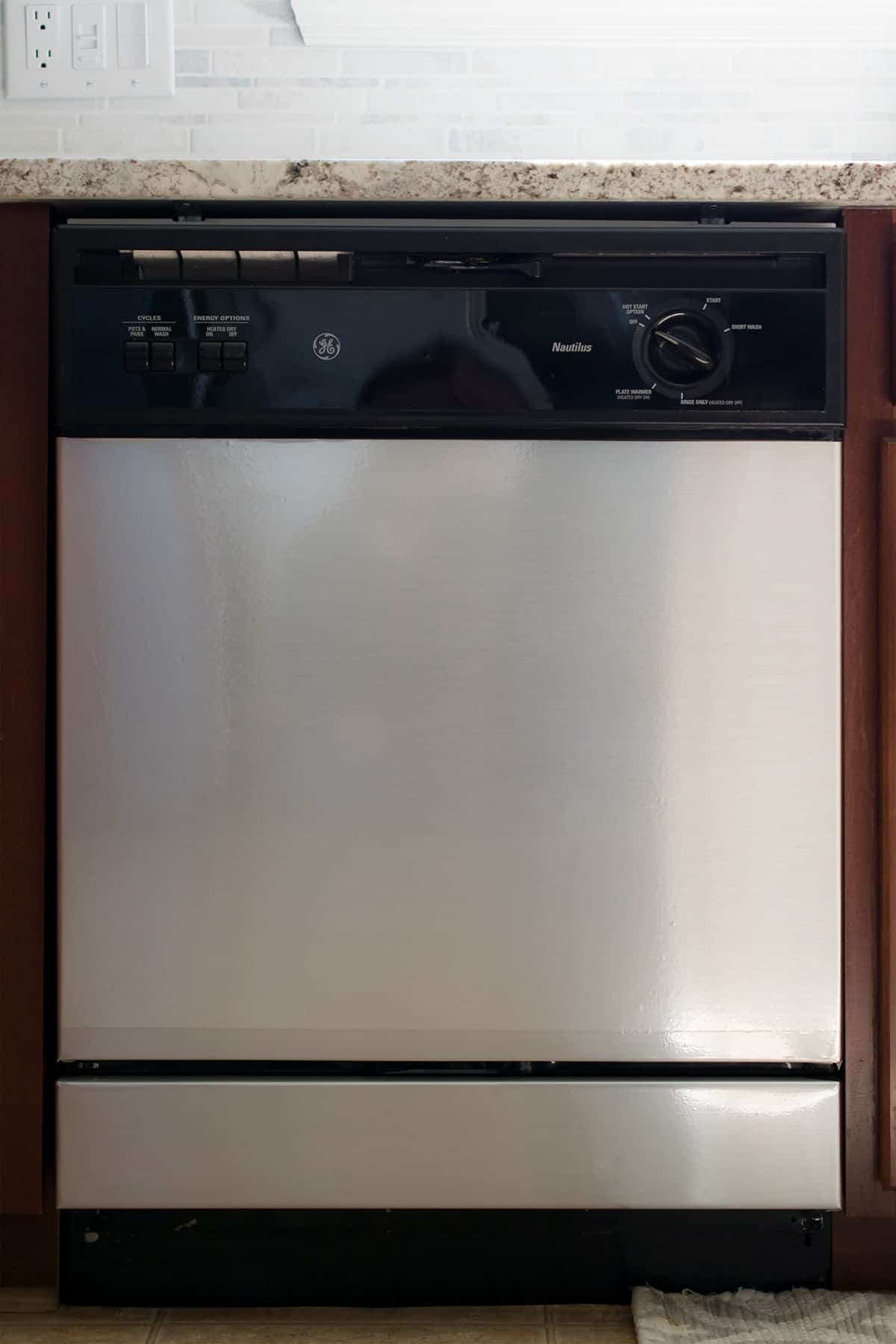 Dishwasher with DIY stainless steel contact paper applied for budget friendly kitchen makeover.