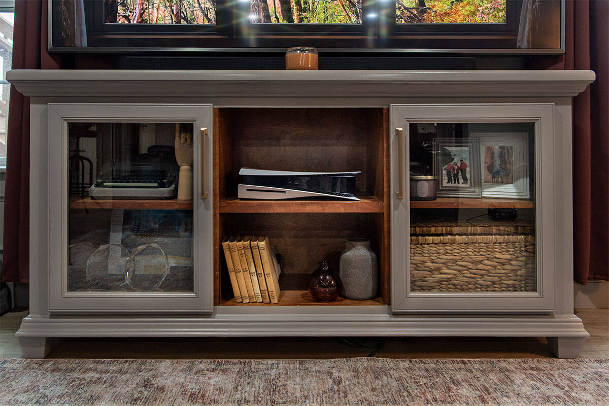 A media cabinet or TV credenza with glass doors that is painted in Benjamin Moore Willow Creek and stained on the interior.
