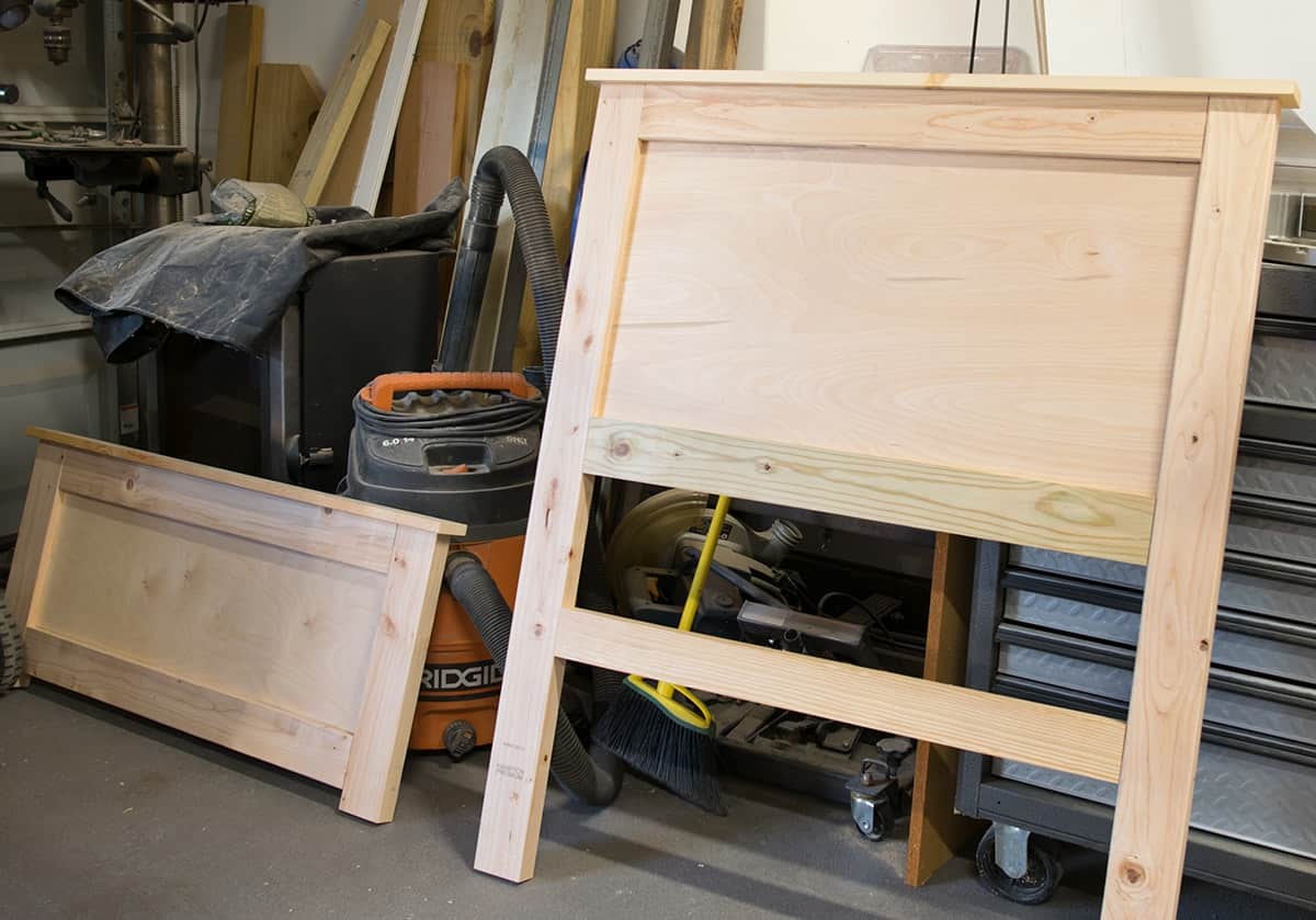 Unfinished Headboard and footboard in garage setting.
