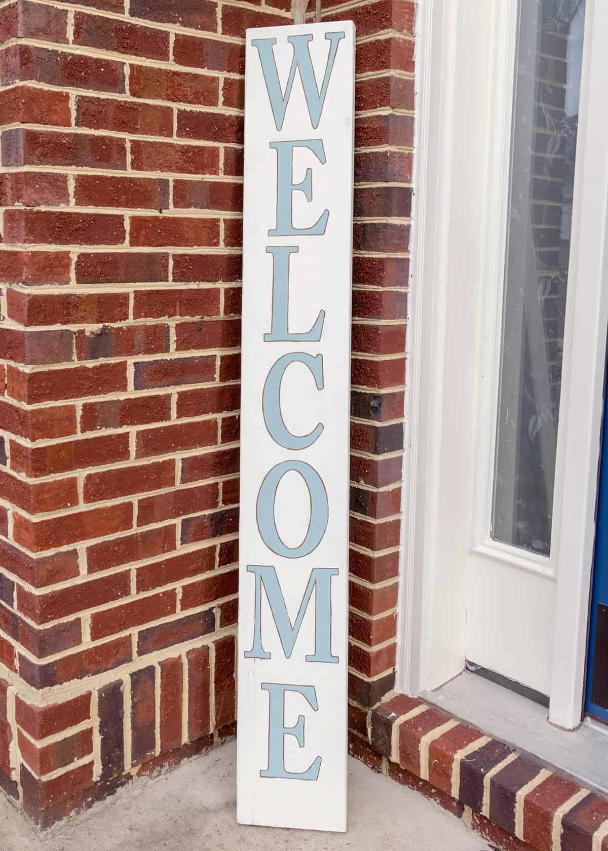 DIY wood welcome sign for porch in white with light blue lettering.