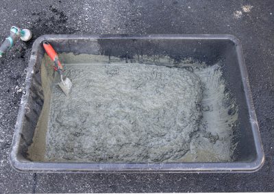 Concrete poured into a container and in the process of mixing with water.