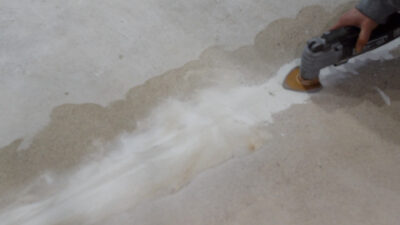Filling a concrete crack and sanding with an oscillating multi-tool.