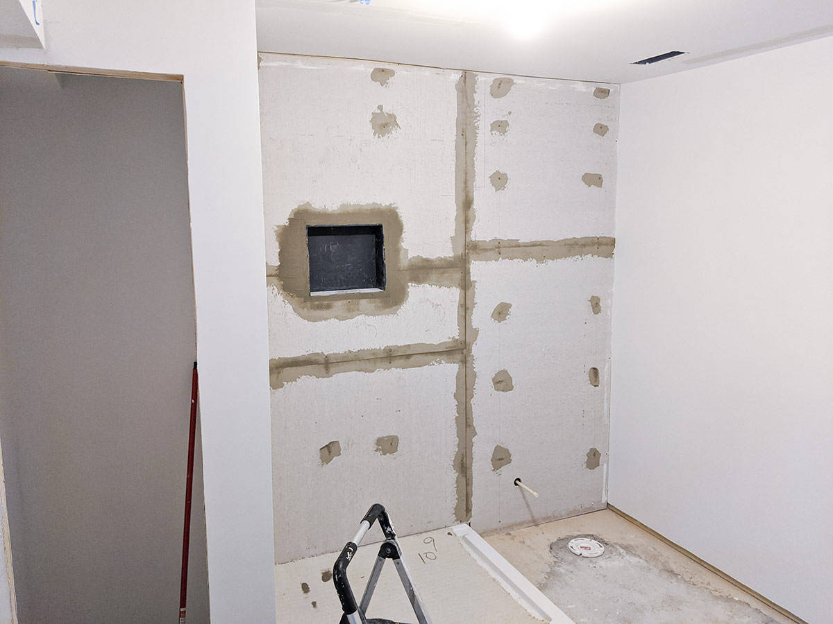 A bathroom in the process of remodeling including cement backerboard and filled seams.