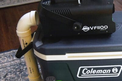 Fog machine next to a pipe on top of a fog chiller.