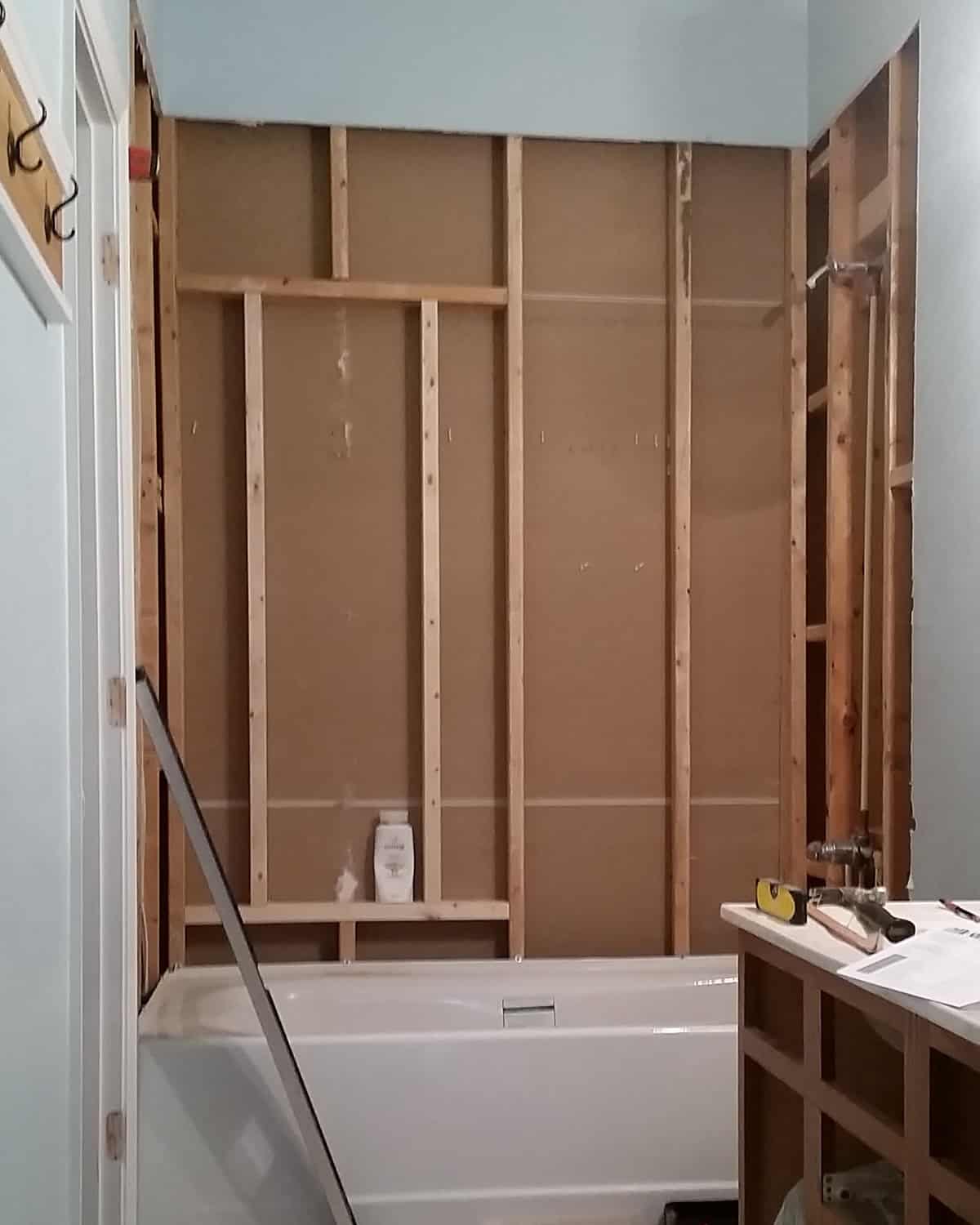 A bathroom remodel with the walls removed to show framing for a large shower niche.