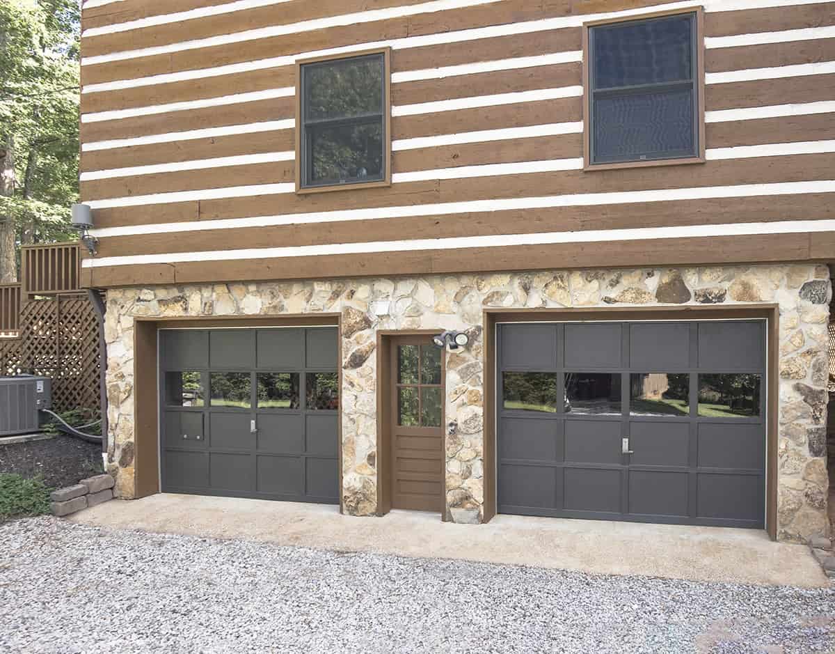 Garage doors painted black on a cabin style home.