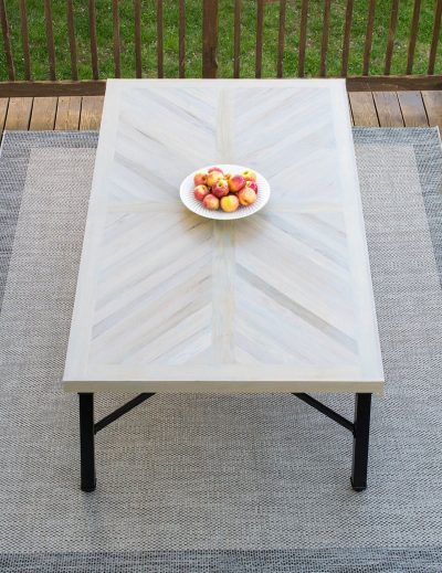 Wood farmhouse table in X cross or herringbone pattern with black legs.