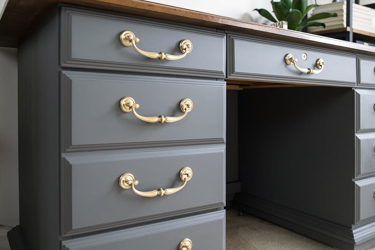 Gray chalk painted desk with gold handles.