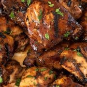 Closeup of grilled chicken thighs with grill marks on them.