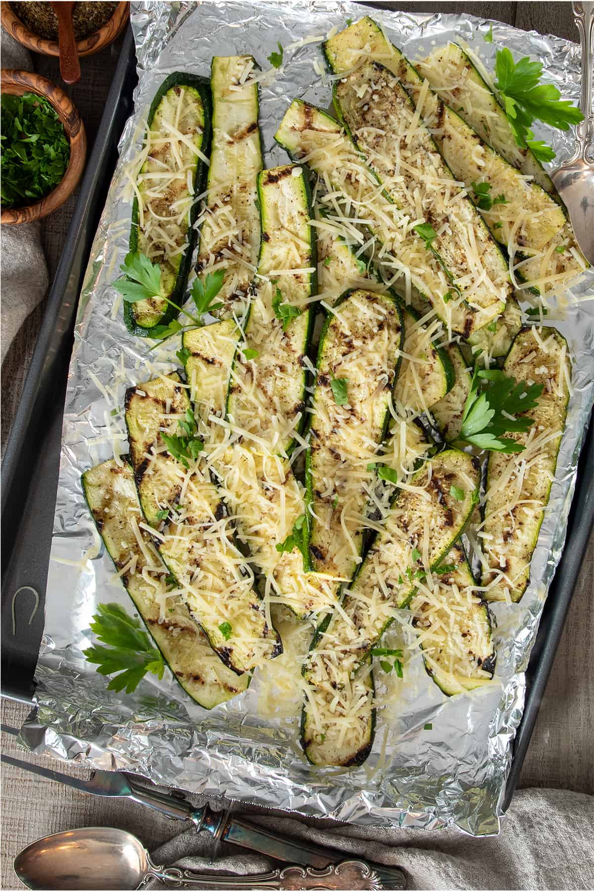 Grilled parmesan zucchini steaks on a foil lined baking dish.