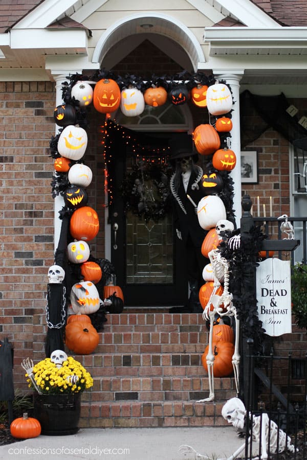 A pumpkin arch over a front door walkway and porch.