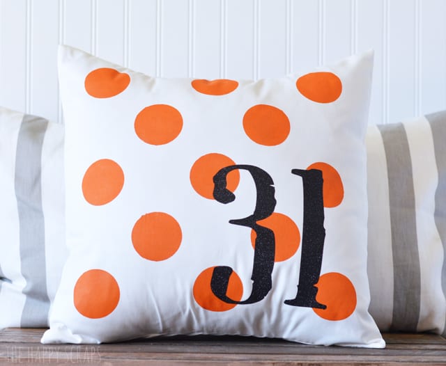 Throw pillow with orange polka dots and the number 31 designed on it.