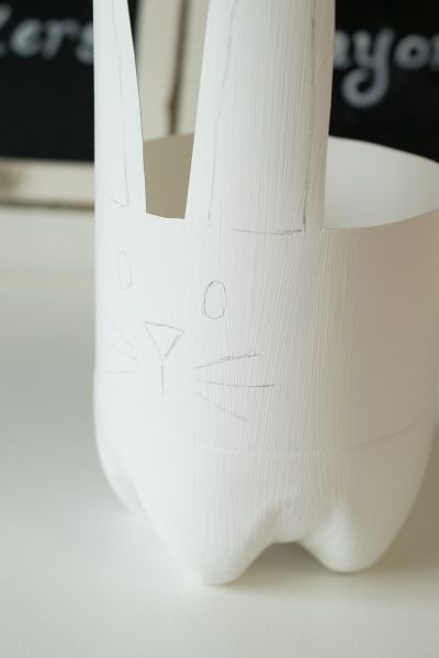 A plastic soda bottle cut into the shape of a bunny for a plant pot.