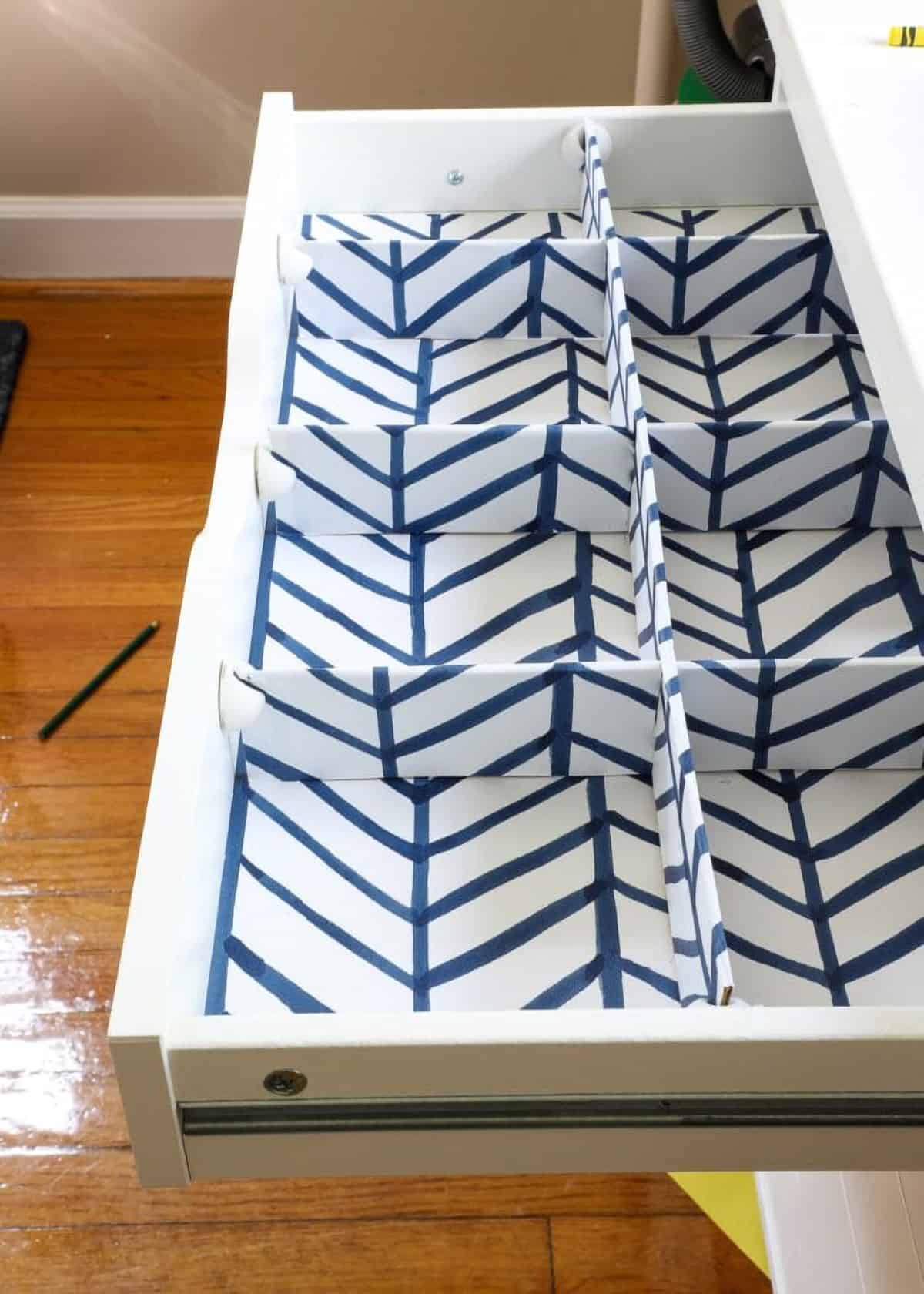 Paper covered cardboard box dividers in an empty drawer.