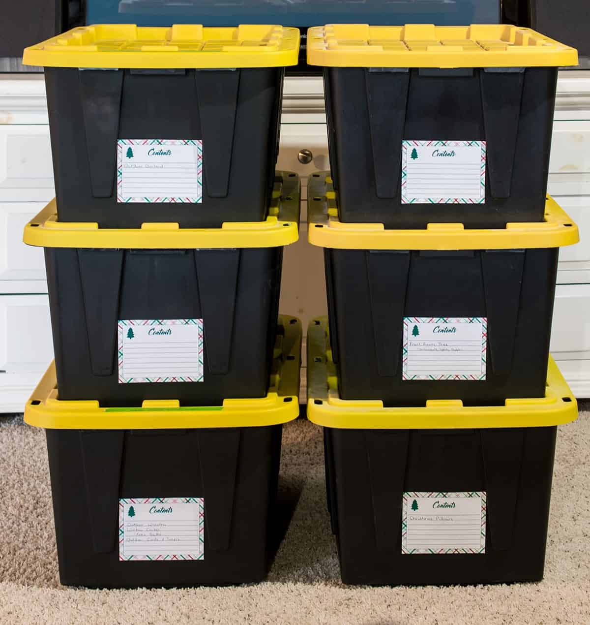Stacked storage containers with lids and labels on them for christmas.