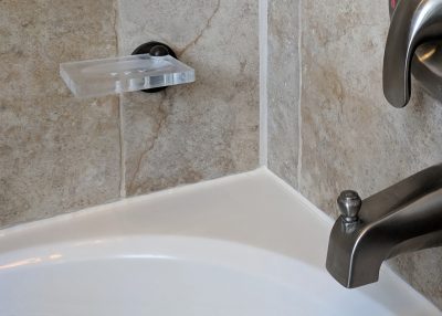 Freshly added caulk to a bathtub surround.
